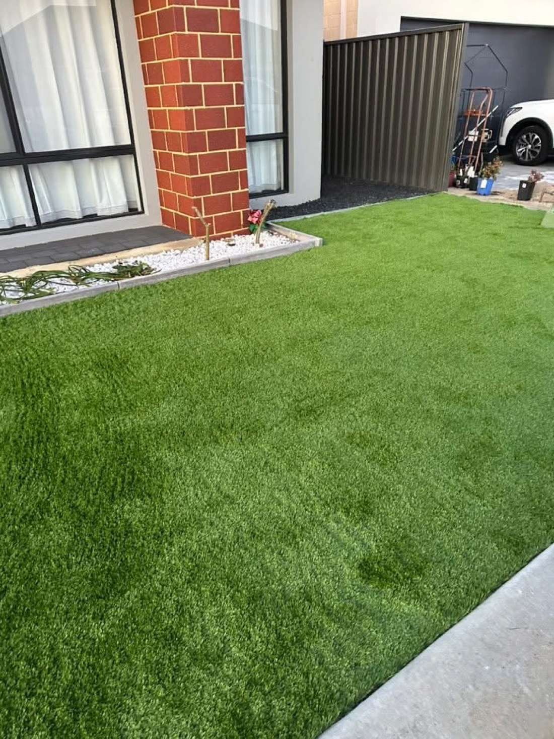 The same entry courtyard with a clean, even, lush new turf install, after installation.
